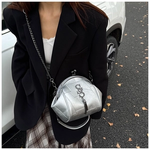 Detail der silbernen Metallic-Muscheltasche mit Kettenriemen und Fransenanhänger im Streetstyle