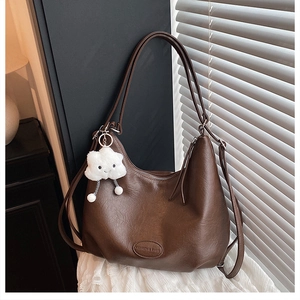 Detailed close-up of brown PU leather texture and plush cloud charm on a retro tote bag