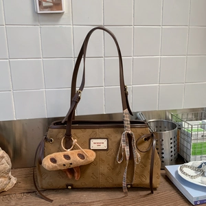 Détail du cabas vintage marron avec gaufrage Bread Cat et breloque en peluche