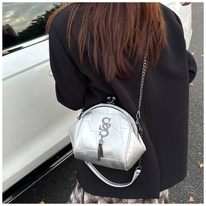 Silberne Kettenschultertasche mit Metallfransen, getragen zu einem schwarzen Blazer
