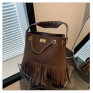 Vue détaillée du sac seau marron foncé matelassé avec longues franges et serrure dorée