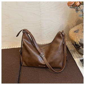 Detail der großen braunen PU-Ledertasche mit goldenem Reißverschluss und Trageriemen