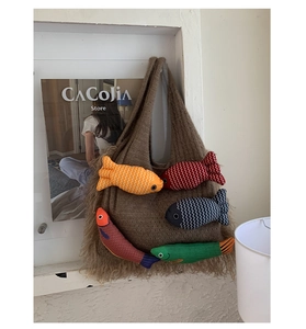 Detail of brown knit tote bag with long tassels and colorful plush fish pendants