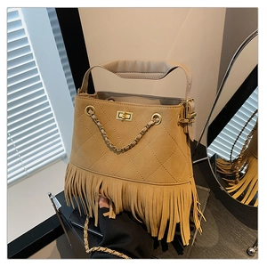 Détail du sac seau en daim kaki avec des franges et un fermoir doré pivotant