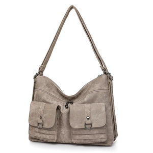Detail of vintage khaki canvas shoulder bag with dual front pockets and metal hardware
