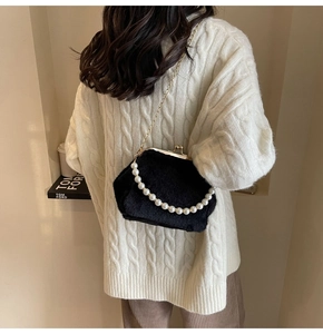 Détail arrière d'un sac coquillage en peluche noire avec anse en perles et chaîne dorée