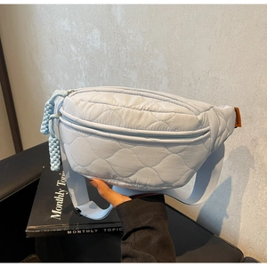 Détail du sac banane matelassé bleu clair avec coutures cœur et sangle tissée réglable