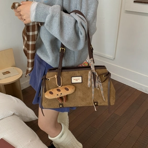 Détail du sac cabas marron vintage avec imprimé chat et pendentif en peluche doux
