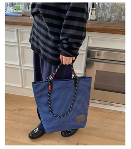 Dettaglio della grande borsa tote a quadri blu con manici in corda in stile lifestyle