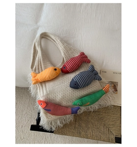 Detail of knit tote bag featuring colorful fish charms and bohemian tassel fringe trim