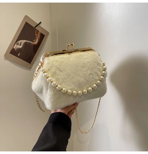 Détail du sac coquillage en fausse fourrure blanche avec anse perlée et chaîne dorée