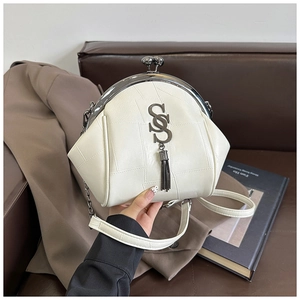 Detail der cremeweißen Vintage-Muscheltasche mit goldenem SS-Logo und Quaste