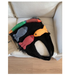 Close-up of knit tote bag with colorful 3D fish appliques on a soft fabric surface