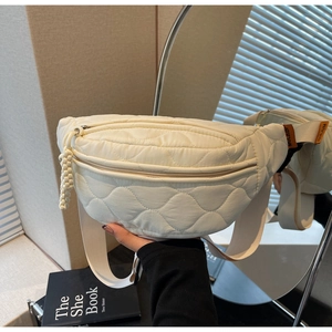 Détail du sac banane matelassé crème en nylon avec motif de losanges et tirette tissée