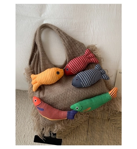 Close-up of brown knit tote bag with tassel fringe and five colorful fish plush charms