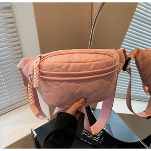 Détail du sac banane en toile matelassée rose avec sangle réglable et étiquette de marque