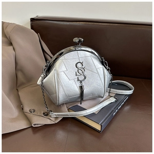 Detail der silbernen Muscheltasche mit Metallstruktur, Klickverschluss und Quastenanhänger