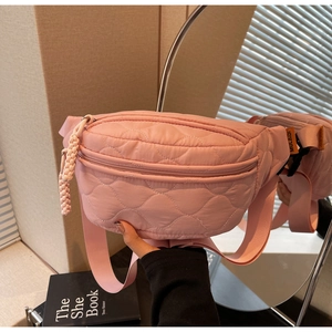 Détail du sac de poitrine en nylon matelassé rose montrant la texture et l'étiquette