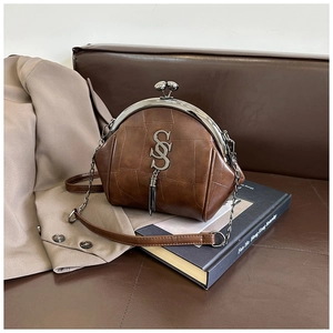 Detail der braunen Retro-Umhängetasche mit Vintage-Textur und metallischem Bügelverschluss