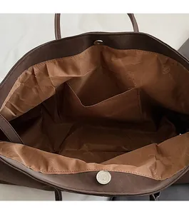 Detail view of the large tote bag showing magnetic closure and interior pocket lining