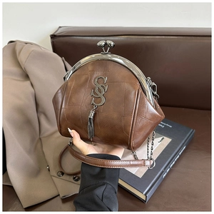 Detail einer braunen Retro-Bügeltasche aus Leder mit Klickverschluss und Quastenanhänger