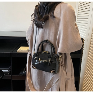 Detail of vintage black Boston bag with leather straps and metal rivets on a shoulder strap