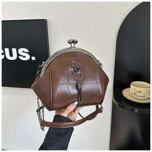 Detail der braunen Vintage-Umhängetasche aus Leder mit Kussverschluss und Quastenanhänger