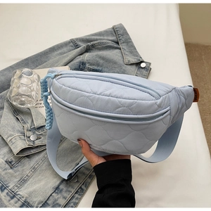 Gros plan sur le sac banane matelassé bleu clair avec coutures en losange et sangle large