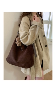 Detail of soft brown suede hobo bag featuring a cute detachable plush bear pendant charm