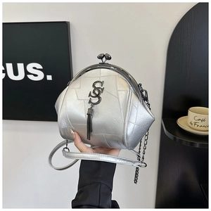 Detail der silbernen Muschelumhängetasche mit Metallverschluss und Quastenanhänger im Lifestyle
