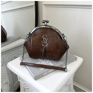 Nahaufnahme der braunen Vintage-Clip-Tasche mit SS-Metalllogo und Quasten-Detail