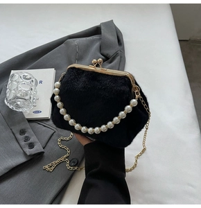 Détail du sac coquillage en fausse fourrure noire avec anse en perles et fermoir doré