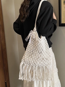 White handmade macrame tote bag with fringe tassels and a delicate lace bow charm