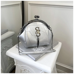 Detailaufnahme silberne Muschel-Tasche mit Metallverschluss und Quastenanhänger