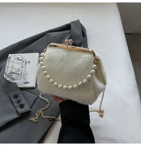 Détail du sac de soirée en fausse fourrure blanche avec anse perlée et fermoir doré