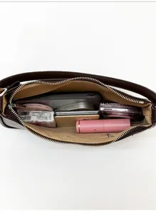 Top view of dark brown baguette bag showing interior storage capacity for daily essentials