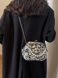 Sac en fausse fourrure léopard avec anse en perles et chaîne dorée porté par un modèle