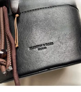 Close-up of black leather bucket bag with textured grain and Paris embossed lettering
