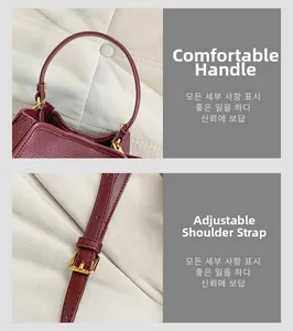 Detail of burgundy leather tote showing soft handles and adjustable golden metal buckle