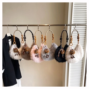 Detail of plush crescent bags with wooden bead handles and leopard cat charms