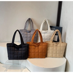 Detailed display of five color options for large quilted padded tote bags in a studio