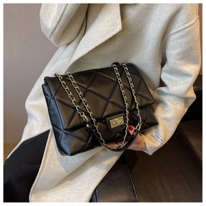 Detail of classic black quilted shoulder bag with premium gold twist lock and chain strap