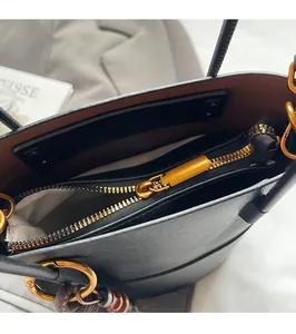 Detail of premium black lychee leather bag showing smooth gold zipper and puller hardware