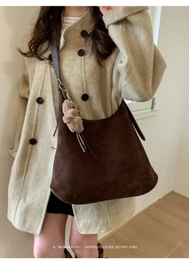 Detail of dark brown faux suede crescent tote bag with a cute plush bear charm