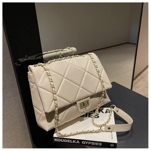 Detail of cream quilted leather bag with gold twist lock and chain strap