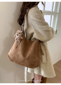 Brown suede tote bag with a cute plush bear pendant shown on model in retro style