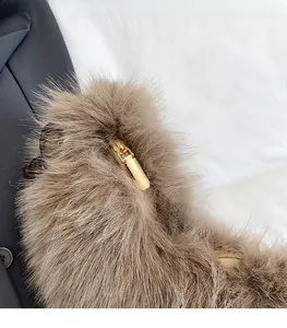 Close-up of fluffy brown plush fabric texture and polished gold metal zipper slider