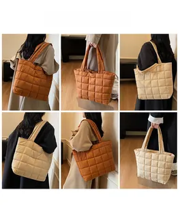 Detail view of quilted puffer tote bag with large square stitching and padded handles