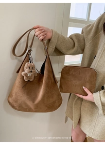 Detail of brown faux suede tote bag with plush puppy charm and matching inner pouch