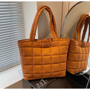 Detail view of quilted caramel puffer tote bag with spacious interior and soft padded texture